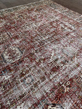 an antique heriz karajah rug with a dark red field and teal blue medallions