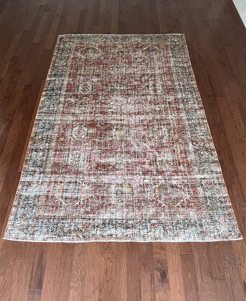 an antique heriz karajah rug with a dark red field and teal blue medallions