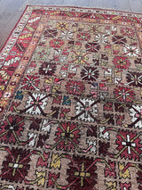 an antique bijar rug with yellow and brown flowers on a camel field