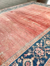 An antique heritage Bakshaish Serapi rug with a pretty peach field, natural abrash and a prussian blue border