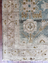 a vintage malayer rug with a faded sea green field with blue, white and lime green accents