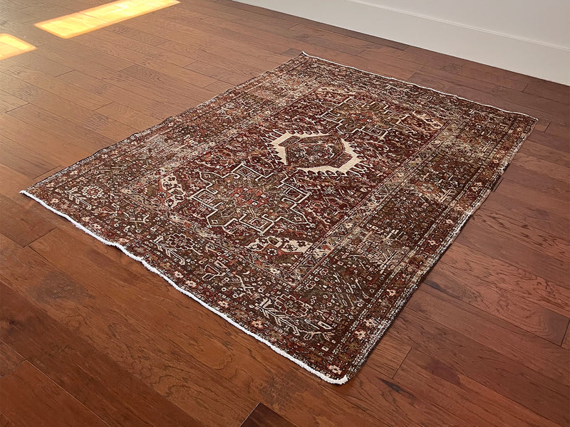 an antique heriz karajah rug with an earthy palette and warm red hues
