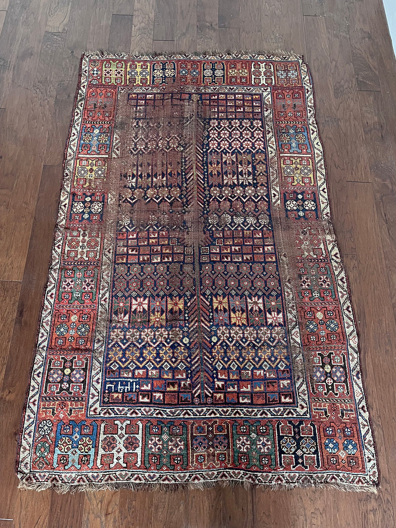 an antique shiraz qashqai with an intricate pattern, red border and midnight blue field