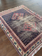 an antique afshar rug with a midnight blue field and a fine paisley pattern