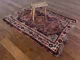 an antique qashqai rug with dark blue field and brown and red accents