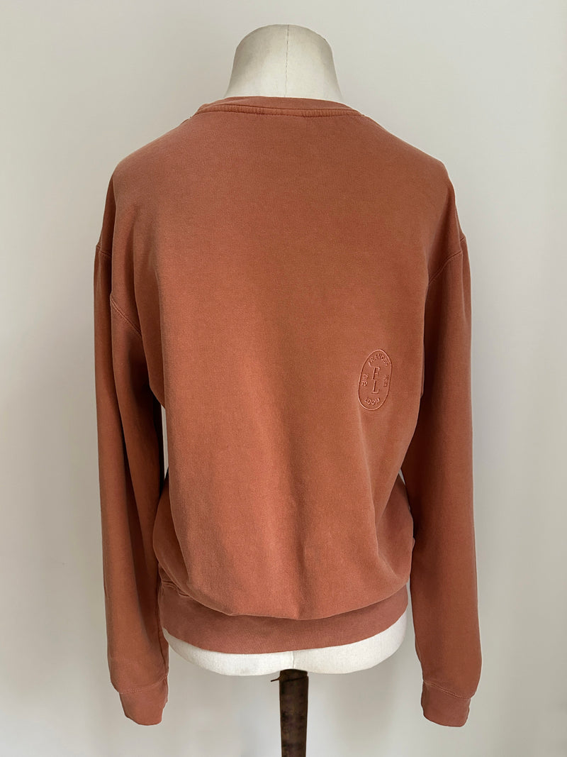 a comfy easy to wear sweatshirt in wam terracotta with 'vintage' embroidered upside down for an abstract look
