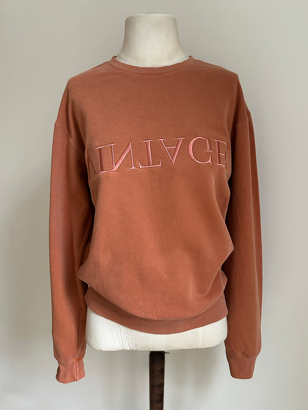 a comfy easy to wear sweatshirt in wam terracotta with 'vintage' embroidered upside down for an abstract look