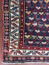 an antique caucasian prayer rug with a midnight blue field and colourful accents
