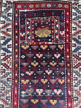 an antique caucasian prayer rug with a midnight blue field and colourful accents