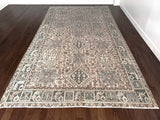 a large heriz karajah rug with blue and brown accents and multiple medallions