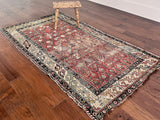 an antique caucasian shirwan rug with a coral field and a pretty trellis pattern in pastel green, blue and yellow tones
