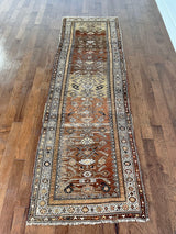 an antique northwest persian runner with a camel, taupe and coral palette and a cream border