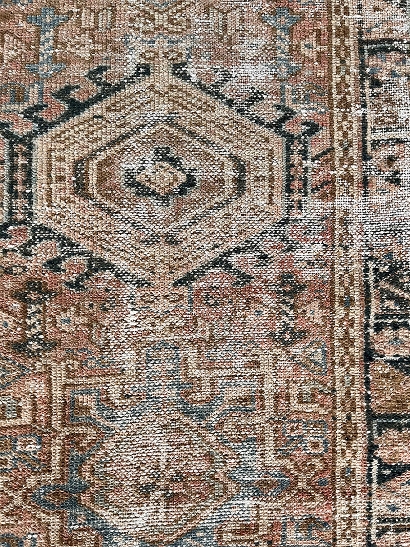 a vintage heriz runner with soft blush undertones and dark blue and brown accents