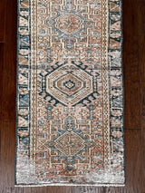 a vintage heriz runner with soft blush undertones and dark blue and brown accents
