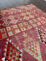 a vintage moroccan rug with a cherry red and pink palette and pretty lilac accents