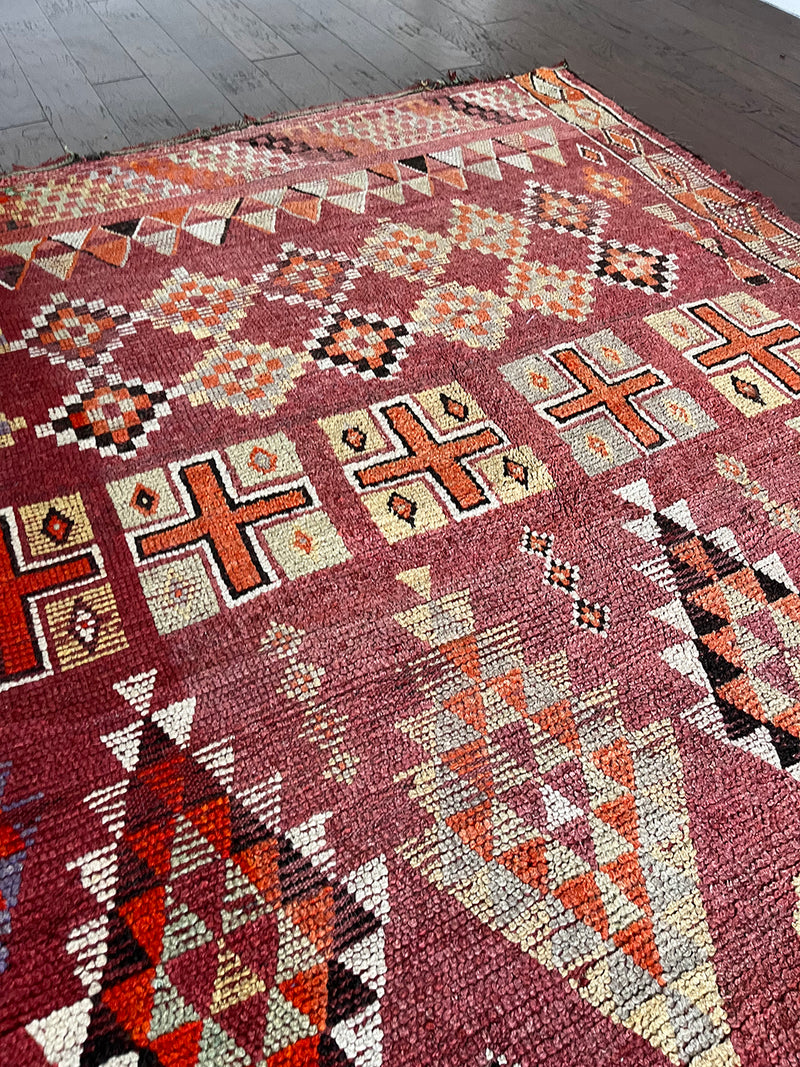 a vintage moroccan rug with a cherry red and pink palette and pretty lilac accents