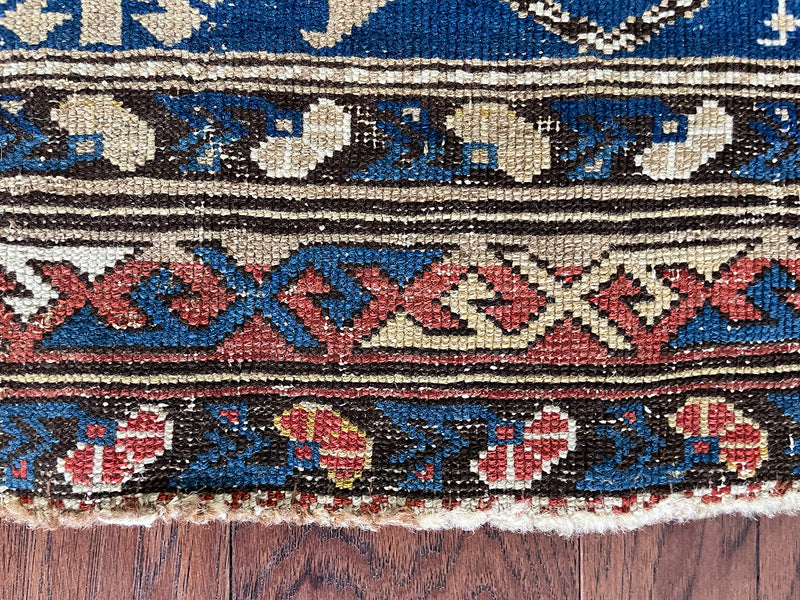 an antique caucasian shirwan rug with an electric blue field and taupe medallions