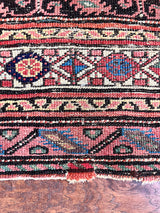 an antique malayer rug with a pretty paisley pattern on a coral field