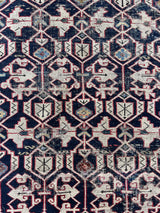 an antique caucasian shirwan rug with a dark blue field and a geometric pattern in cream