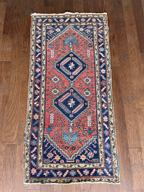 a mini heriz rug with a coral field and bold blue medallion