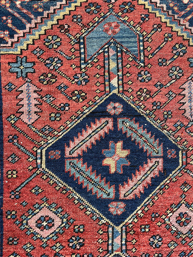 a mini heriz rug with a coral field and bold blue medallion