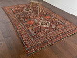 an antique qashqai rug with a dark blue field and intricate colourful details