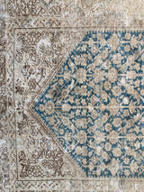 a wide persian runner with a cream and brown border and a blue floral field