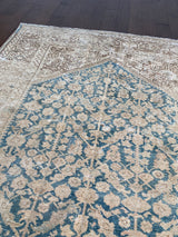 a wide persian runner with a cream and brown border and a blue floral field