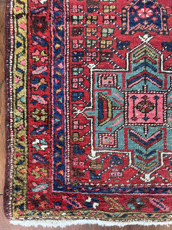 a vintage heriz runner with turquoise and hot pink accents on a red field