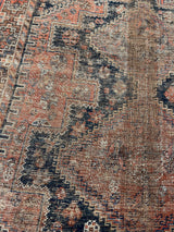 an antique qashqai rug with black and brick red accents