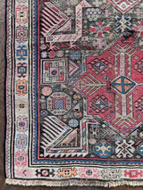 an antique caucasian runner with a taupe field and hot pink medallions 