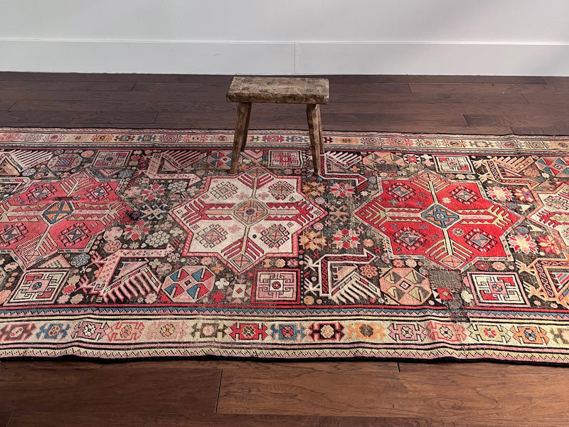 an antique caucasian runner with a taupe field and hot pink medallions 