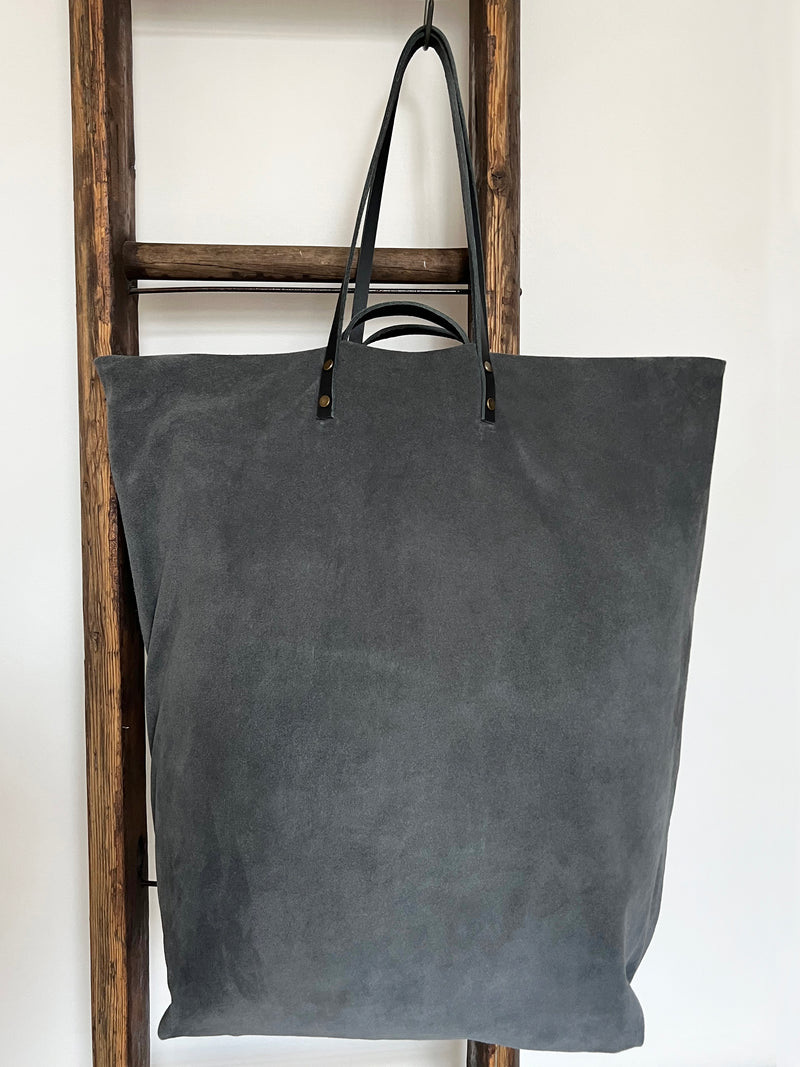 an overnight tote bag made with antique rug and suede
