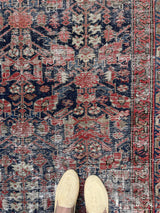 a vintage malayer rug with an indigo field and bright neon pink and red floral accents