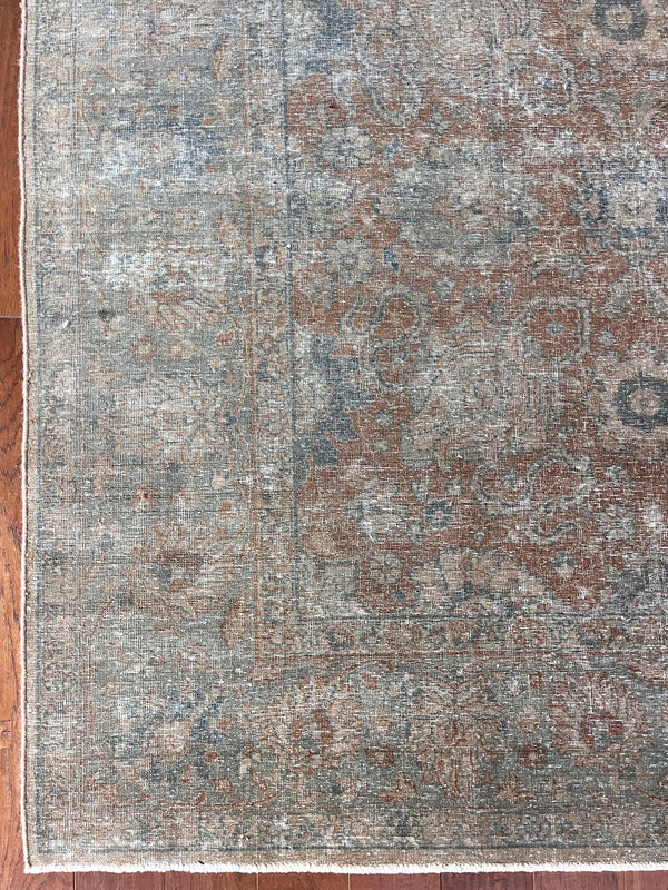 a large vintage tabriz rug with an earthy terracotta palette and a subtle blue floral pattern