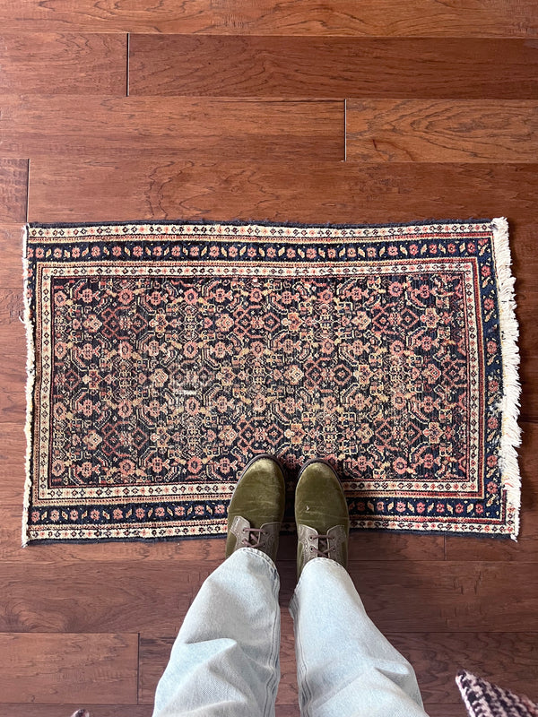 a mini senneh rug with a coral floral pattern