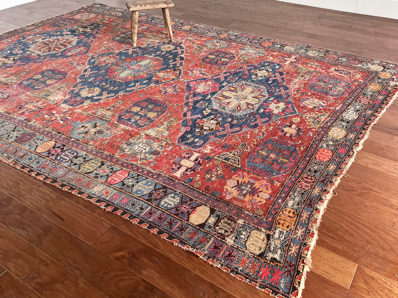 a large antique sumac rug with royal blue central medallions and a red field