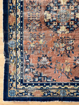 a large antique Chinese rug circa 1900, with a finely woven pile, a coral field and royal blue accents