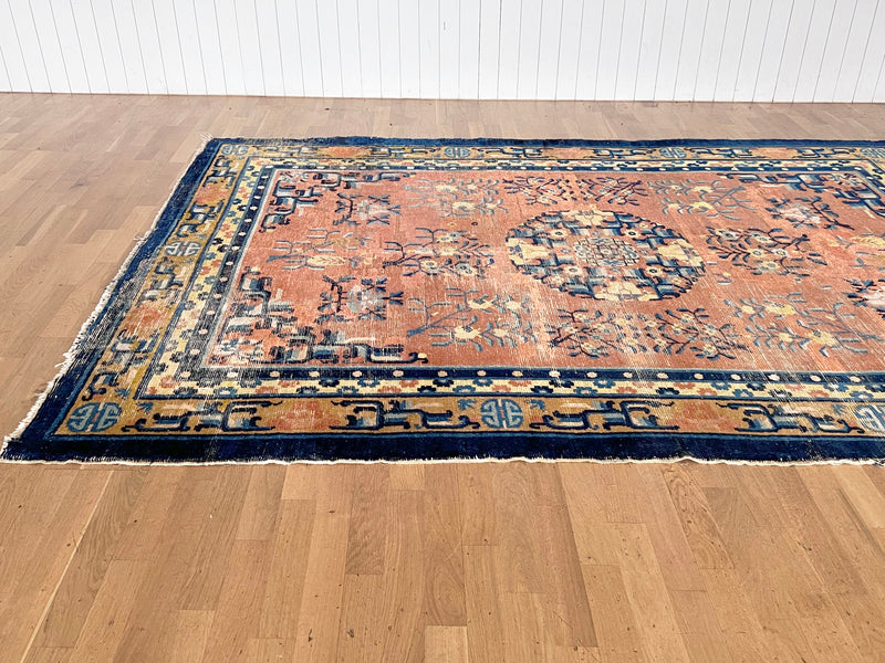 a large antique Chinese rug circa 1900, with a finely woven pile, a coral field and royal blue accents