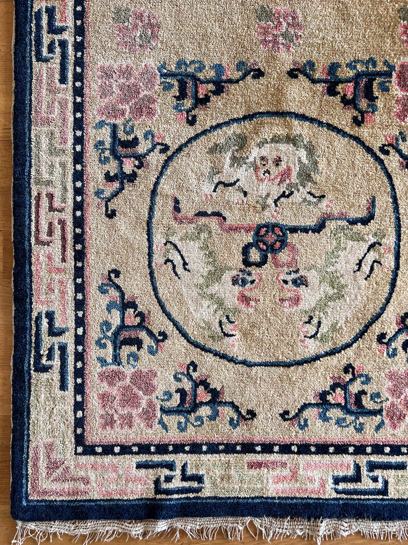 an antique chinese peking runner with a light yellow field and pink and navy accents