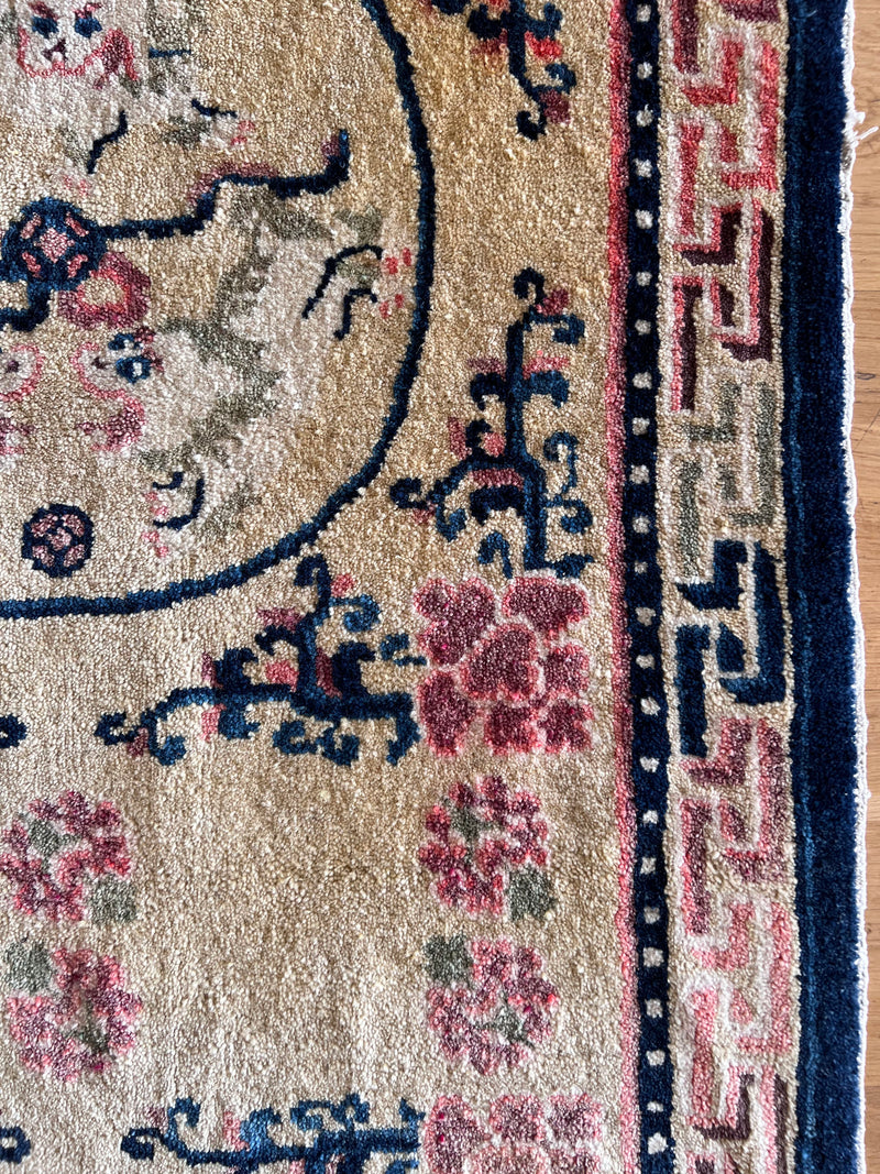 an antique chinese peking runner with a light yellow field and pink and navy accents