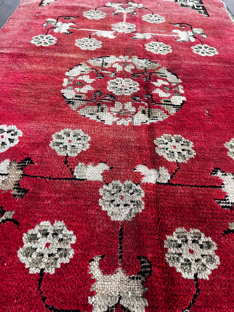 an small antique chinese peking rug with raspberry pink tones