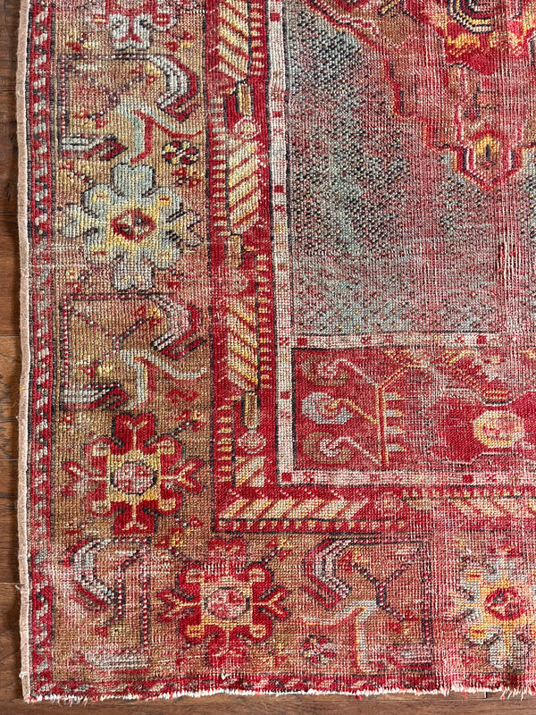 an antique turkish rug with hot pink accents and floral details