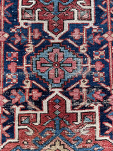 An antique Heriz rug with a blue and brick red palette. 