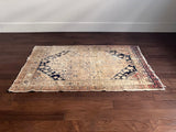 a vintage khotan rug with a neutral palette and small black accents