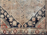 a vintage khotan rug with a neutral palette and small black accents