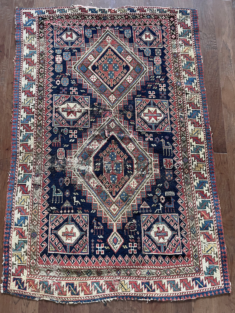 an antique caucasian shirwan rug with a midnight blue field and brick red accents
