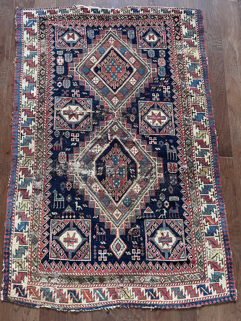 an antique caucasian shirwan rug with a midnight blue field and brick red accents