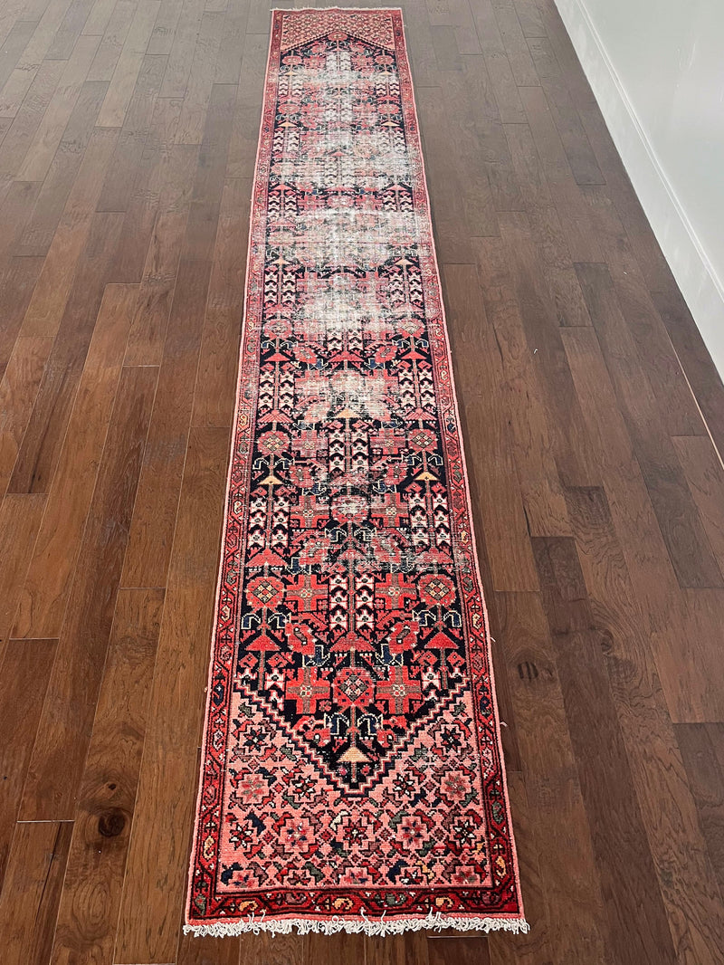 an antique malayer runner with floral hot pink accents