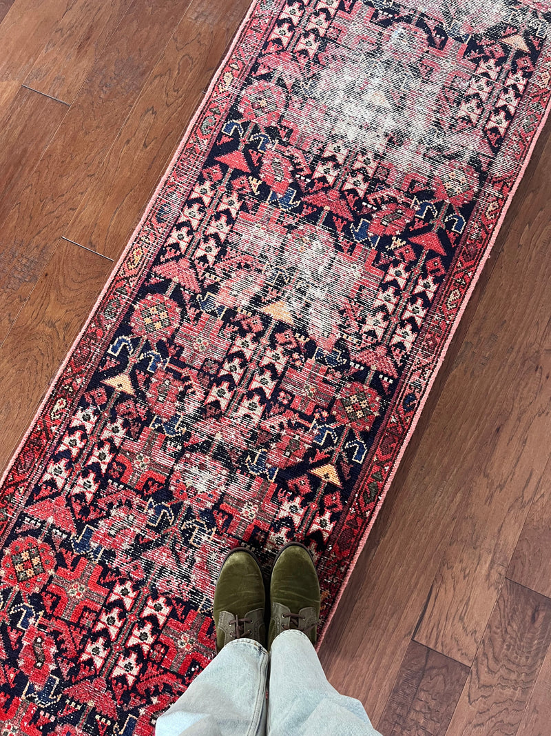 an antique malayer runner with floral hot pink accents